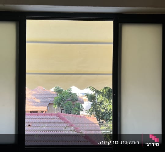 סוכך בד צהוב מותקן מחוץ לחלון הבית להצללה